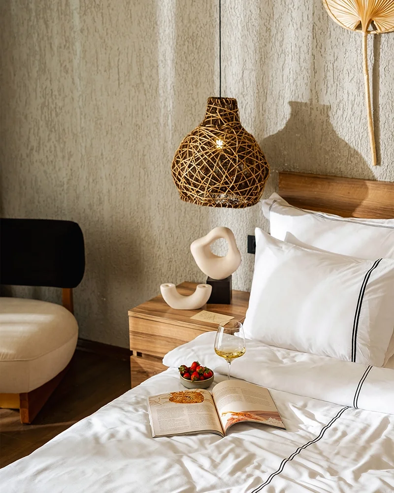 Khai Hotel luxury bedroom interior featuring wicker pendant lamp and modern decor