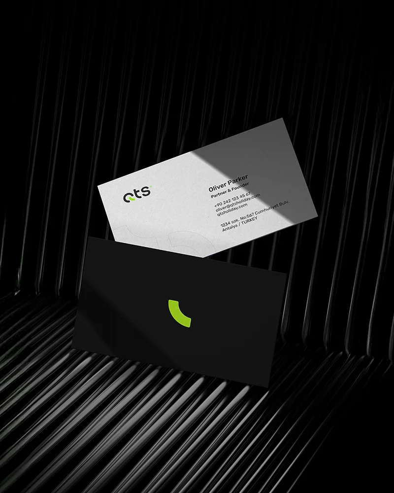 QTS branded black and white business cards mockup on a dark textured background